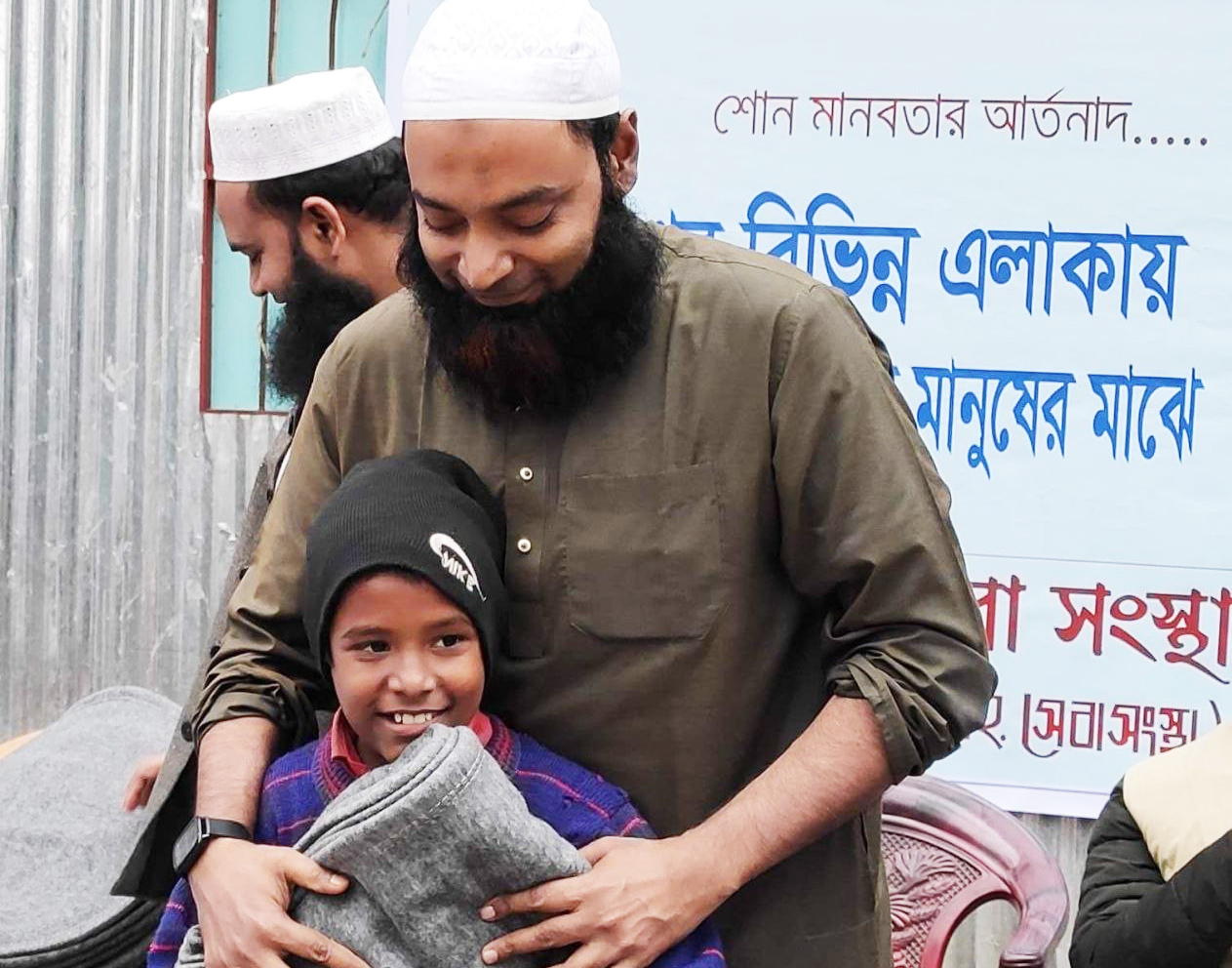 Muhammad Raj giving blanket to a poor girl through project winter cloths distribution