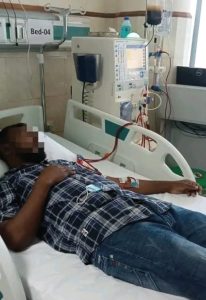An adult patient lying on hospital bed connected with cardiac monitor.