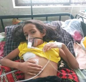 A patient with oxygen mask and IV cannula
