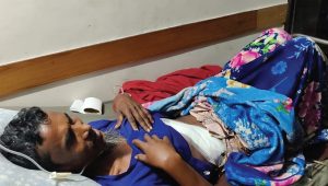 A patient lying on bed with bandage in his abdomrn