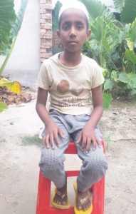 A boy sitting on a stool.