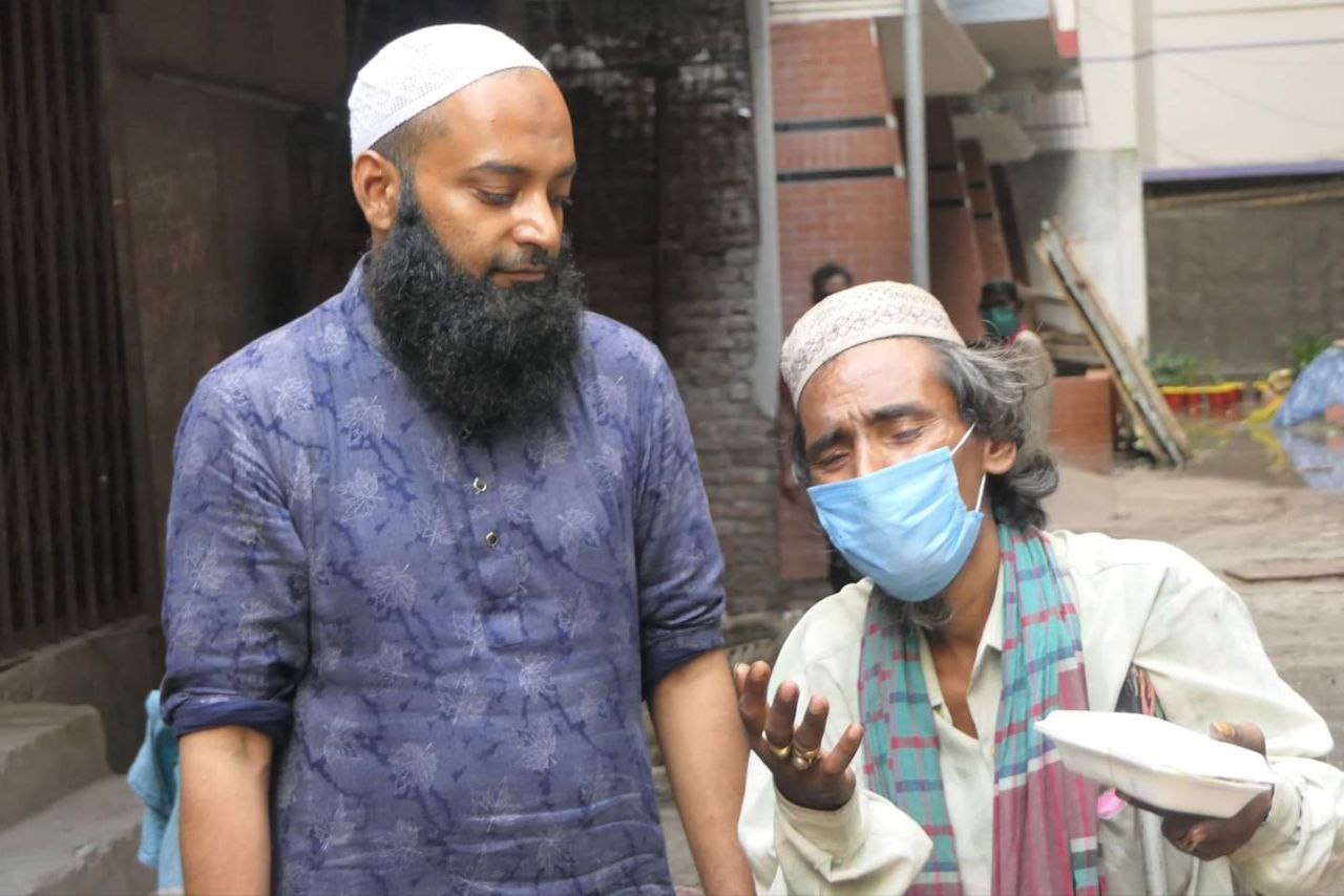 A poor man talking to Muhammad Raj after getting food from him.